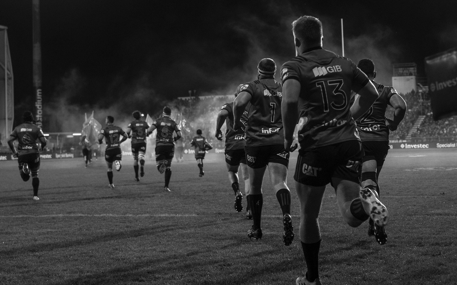 Rugby players running onto the field under stadium lights – Peak Rugby performance and team strength